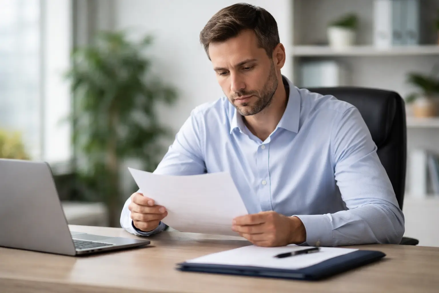 Работник изучает документ об увольнении по соглашению сторон перед подписанием, оценка условий компенсации.